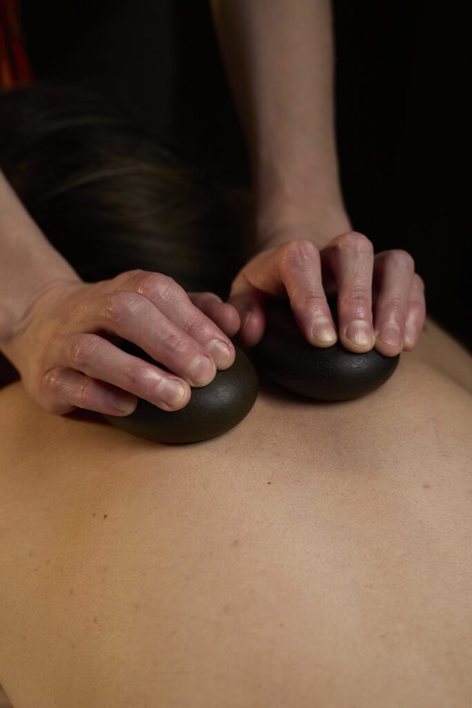 Relaxing hot stone massage treatment to ease muscle tension at Bloor West Retreat in Toronto