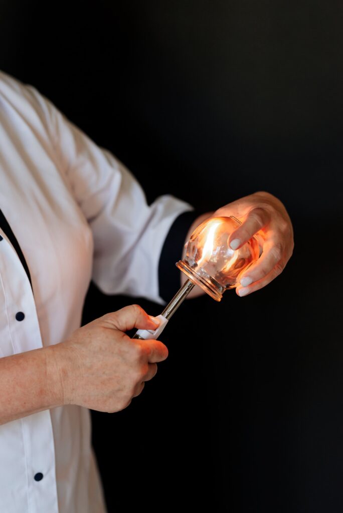 Close-up of therapist preparing fire cup with flame