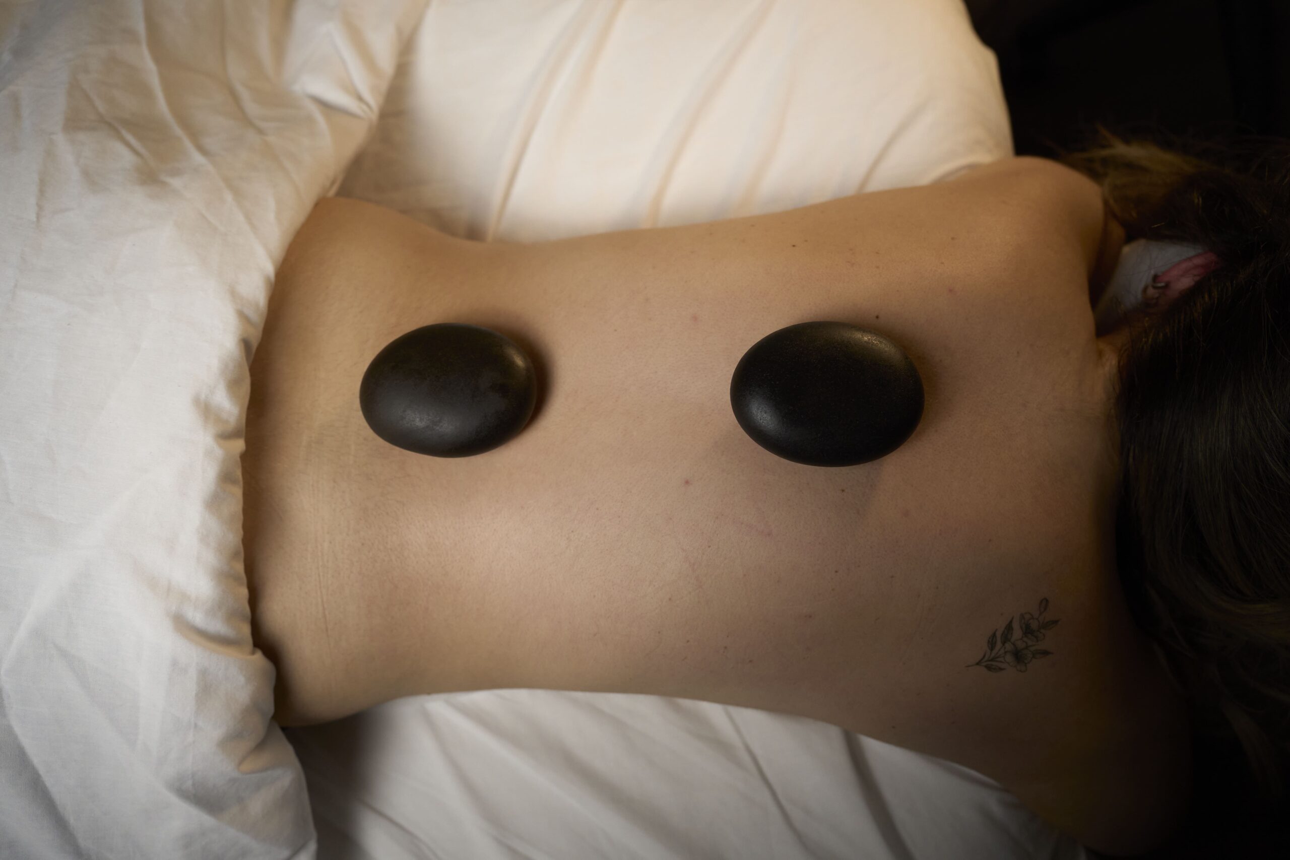 Client receiving a relaxing hot stone massage at Bloor West Retreat